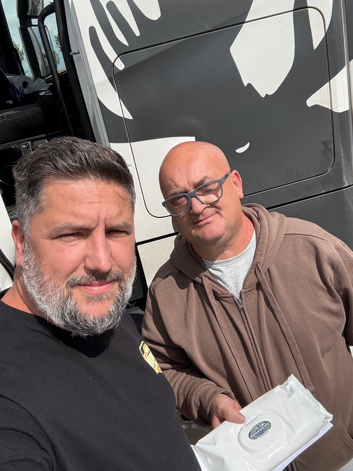 Szemüveges sofőr DriverWipe-pal a kamion előtt